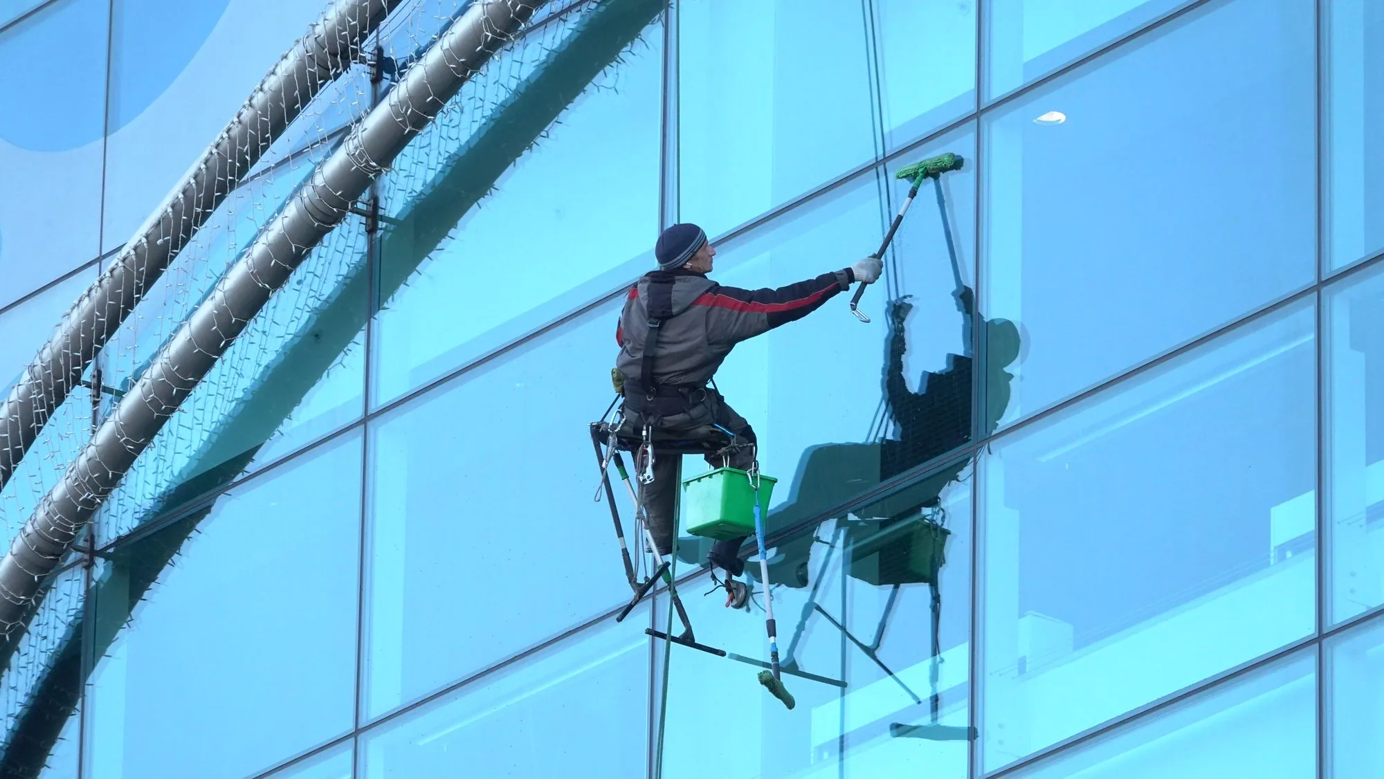 Technician cleaning a high-rise glass facade