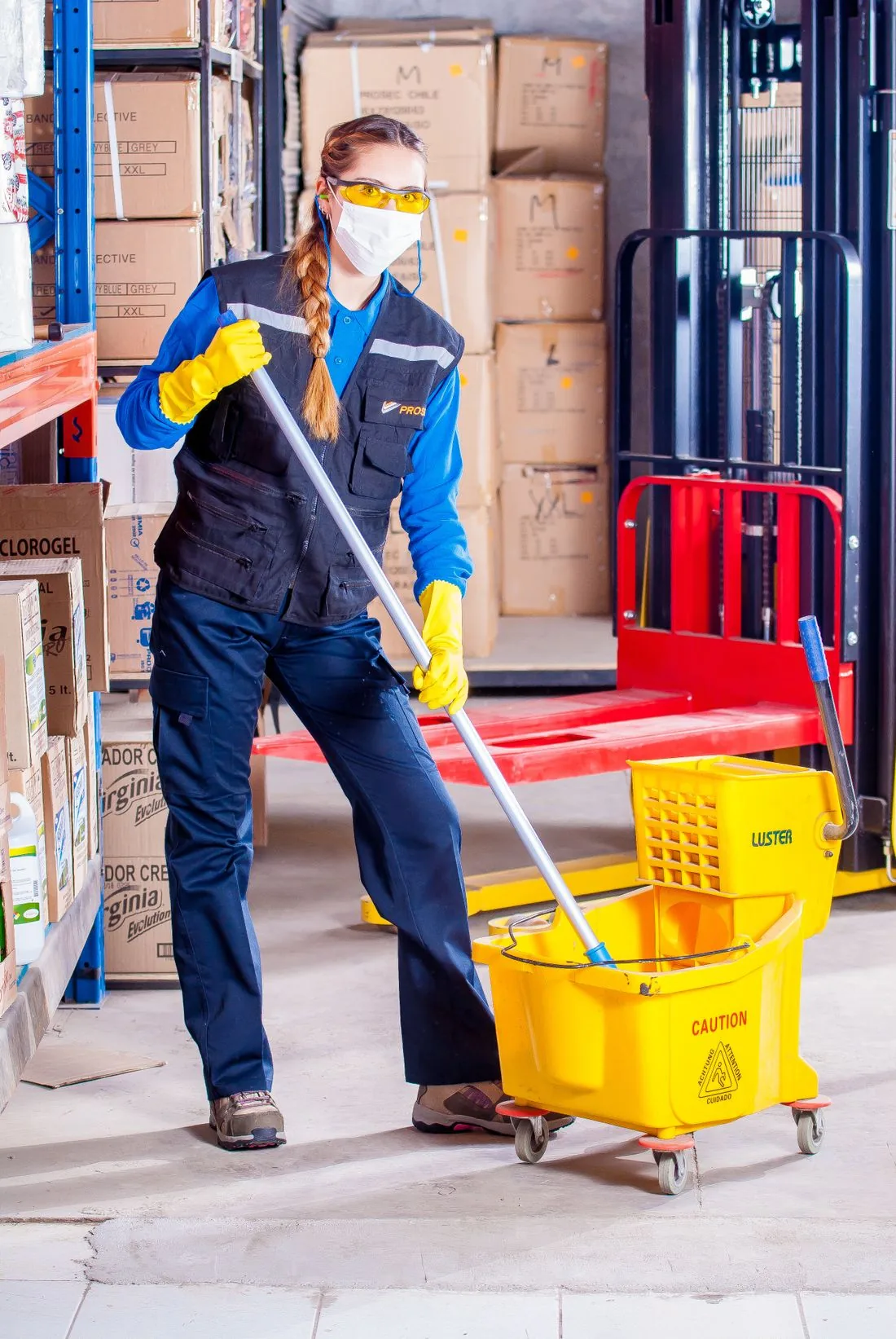 Worker with mop bucket in a warehouse
